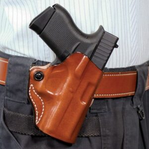 Handgun in a brown leather holster attached to a belt at the wearer's waist.