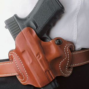 Close-up of a black pistol in a brown leather holster secured to a belt.