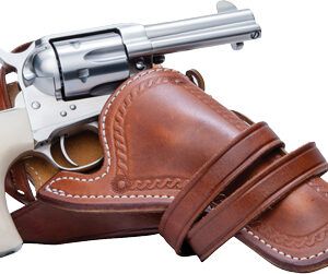 Chrome revolver partly drawn from a brown leather shoulder holster with strap