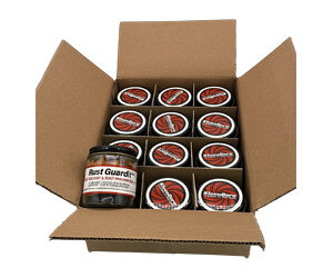 Open cardboard box filled with multiple Rust Guard spray cans, with one larger can visible at the front.