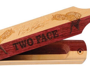Wooden hand plane with the words 'TWO FACE' carved on the side and decorative fish images.