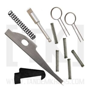 Assorted firearm maintenance tools—springs, punches, a blade, and ring‑handled picks laid out on a white background.