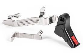 Metal bicycle brake levers with a black lever housing and red trigger piece on the side.